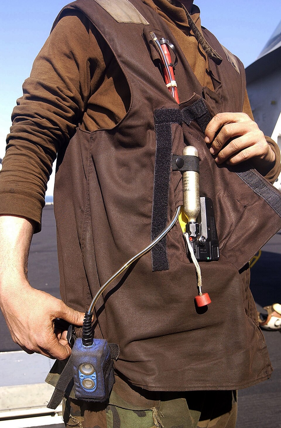 Open float coat showing its gas cylinder, trigger, wiring and man-overboard indicator hardware.